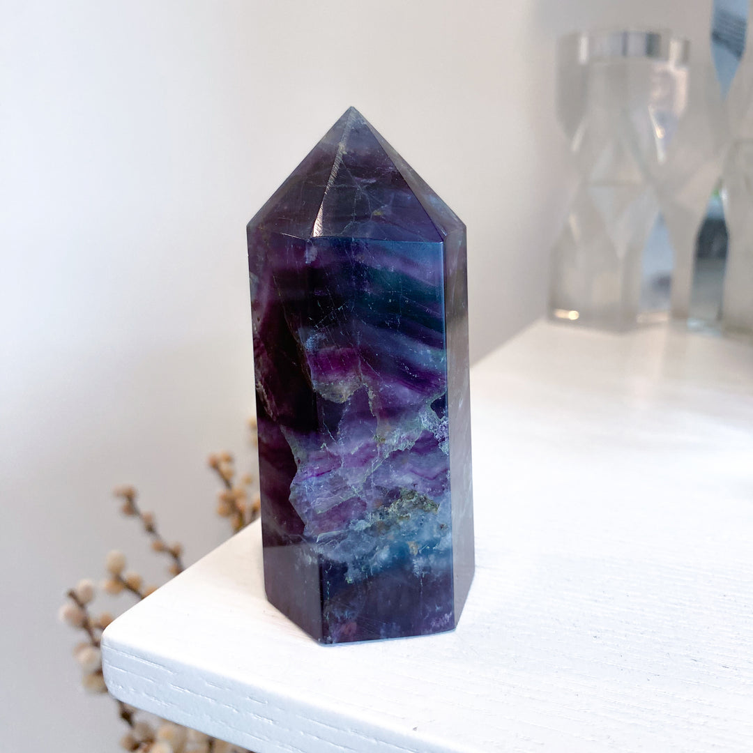 Multicolored crystal tower on a white surface with a blurred background