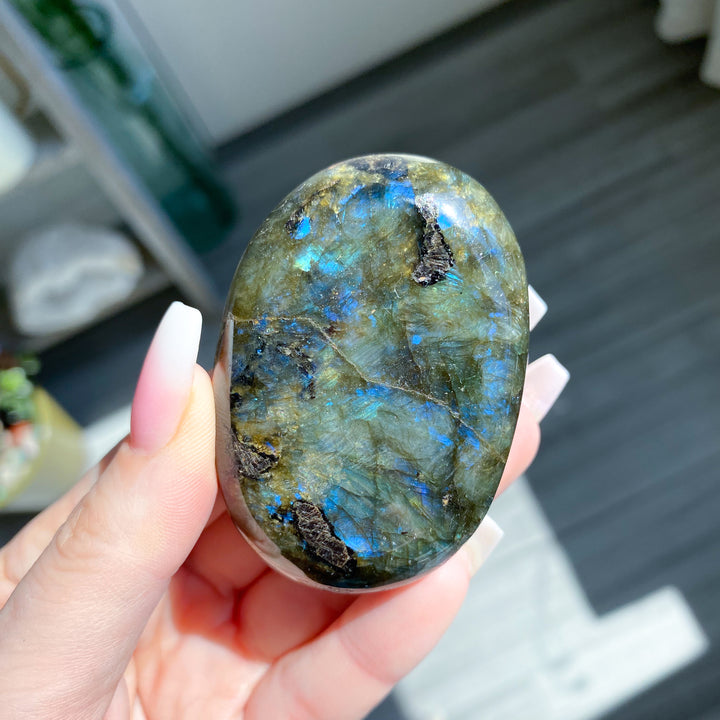 Hand holding a labradorite stone with a blurred background