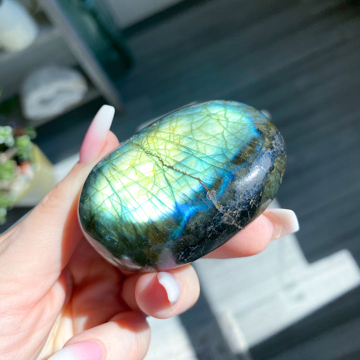 Hand holding a Labradorite stone with a blurred background