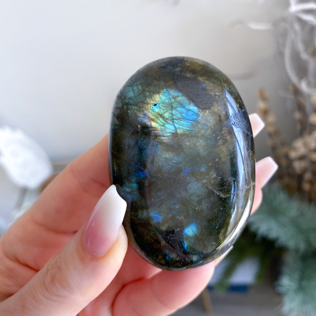 Person holding a labradorite stone with a reflective surface