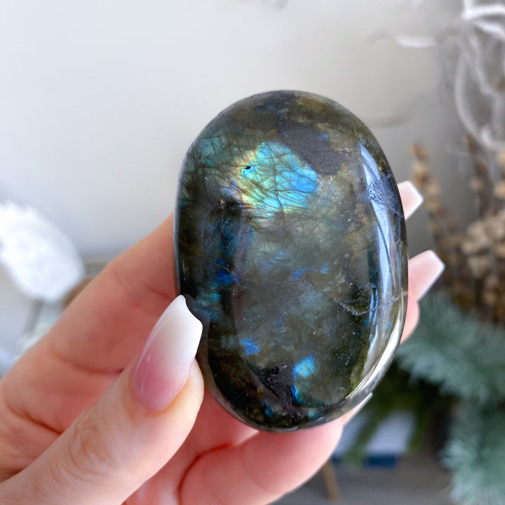 Person holding a labradorite stone with a reflective surface