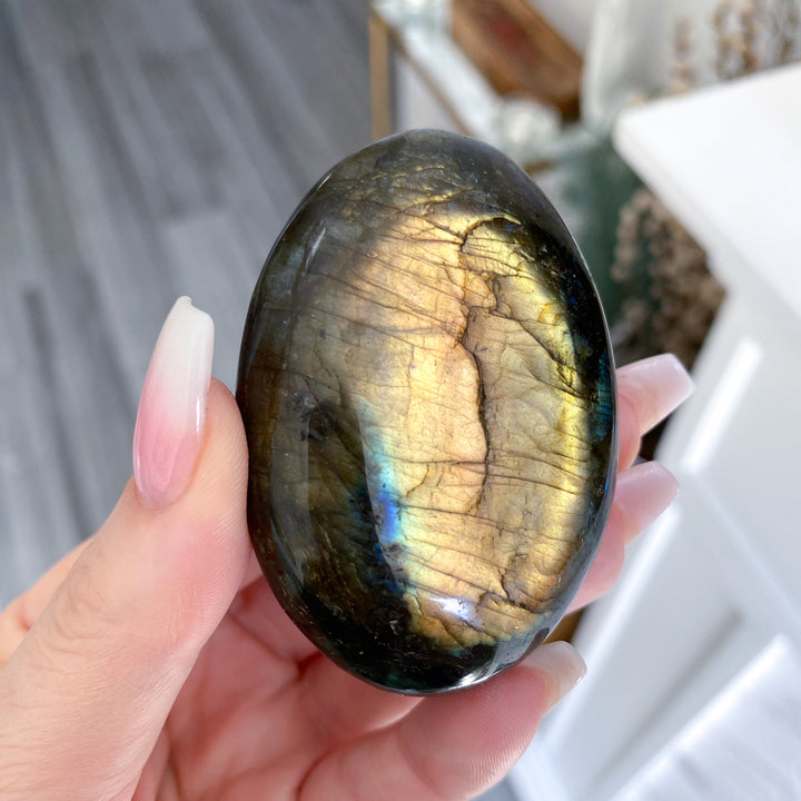 Person holding a labradorite stone with a reflective surface