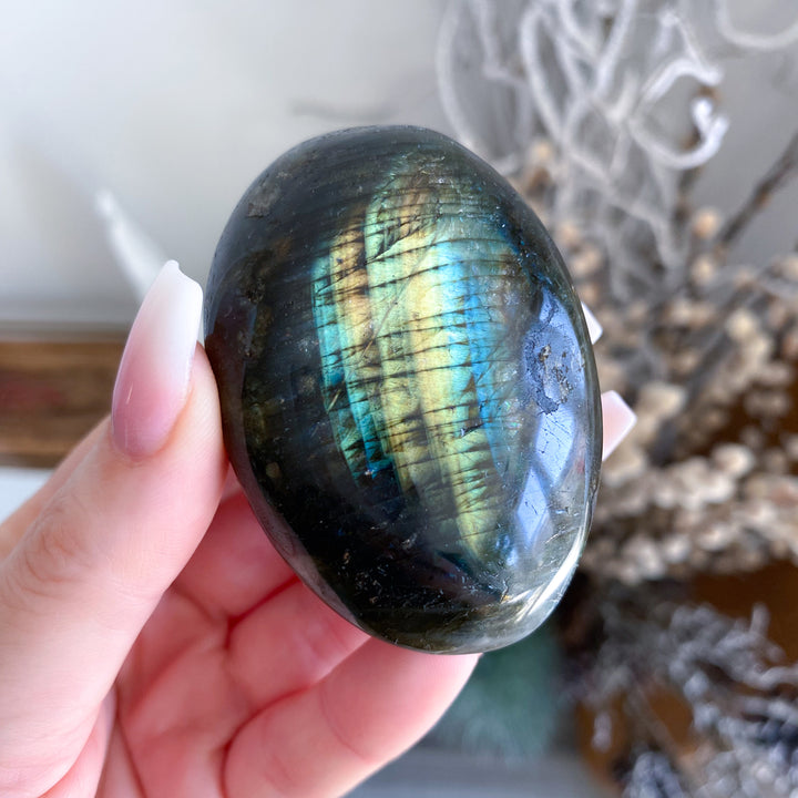 Person holding a Labradorite stone with a reflective surface