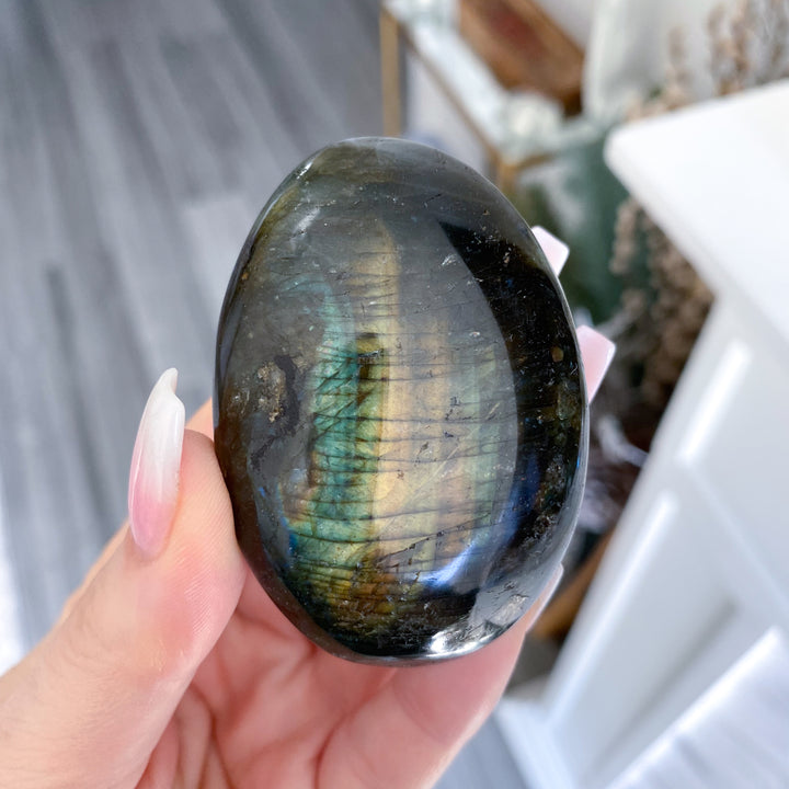 Person holding a labradorite stone with a blurred background