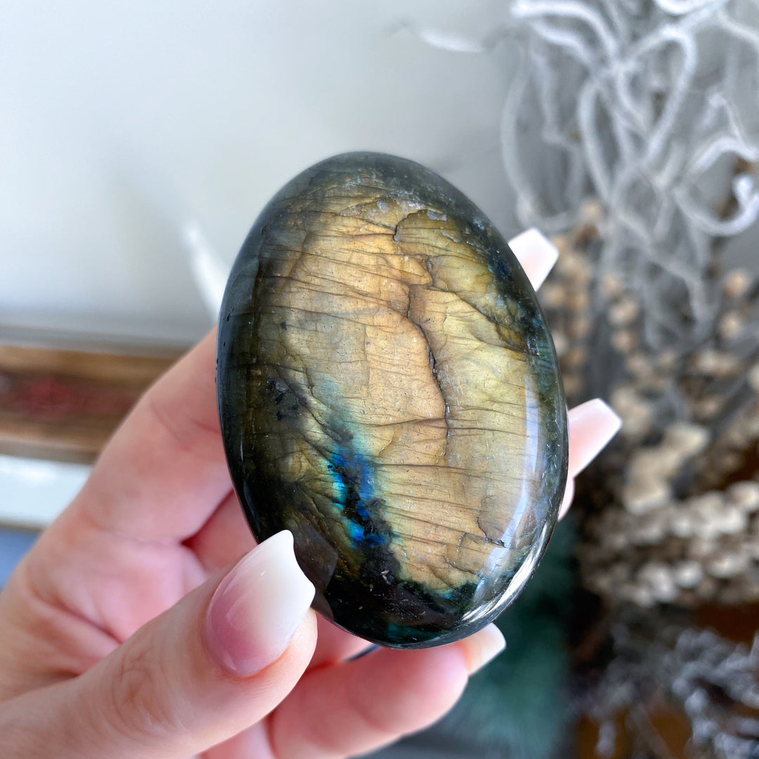 Hand holding a labradorite stone with a blurred background