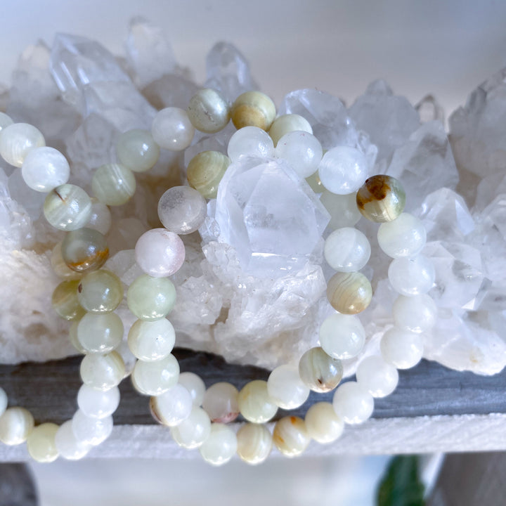 Necklace with green and white beads on a white stone background
