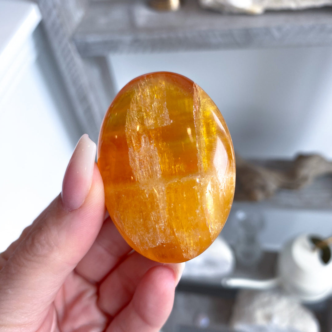 Bright, Juicy Orange Calcite Palm Stone with Rainbows #1