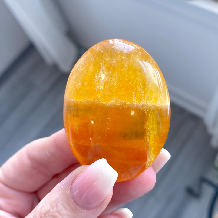 Bright, Juicy Orange Calcite Palm Stone with Rainbows #1