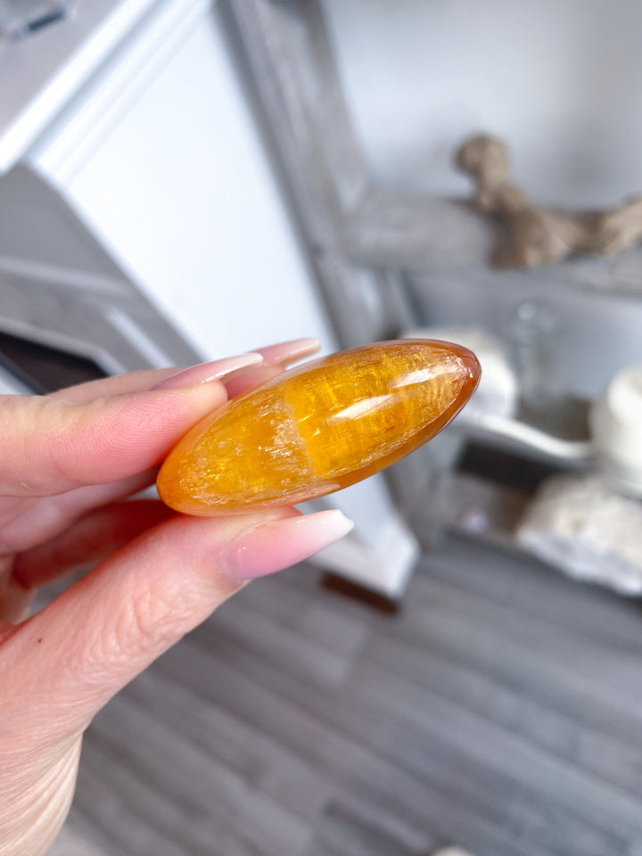 Bright, Juicy Orange Calcite Palm Stone with Rainbows #1