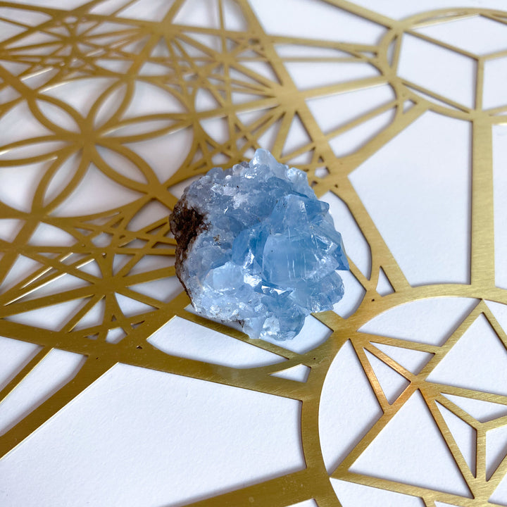 Blue crystal on a gold geometric design