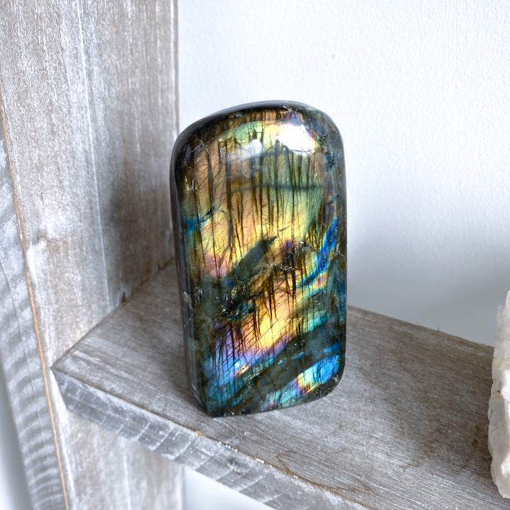 Multicolored labradorite stone on a wooden surface