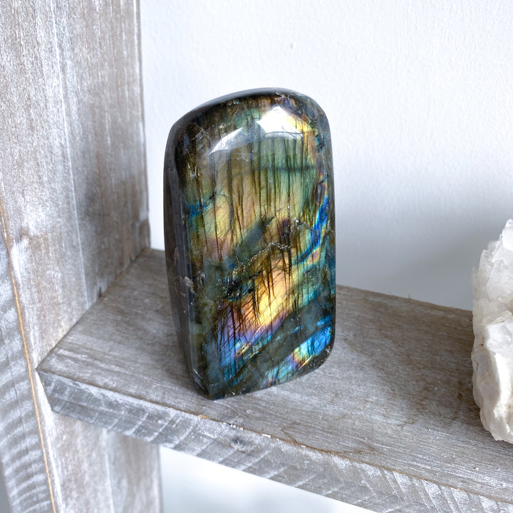 Multicolored labradorite stone on a wooden surface