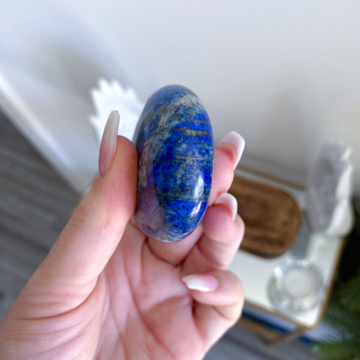 Hand holding a blue stone with a blurred background