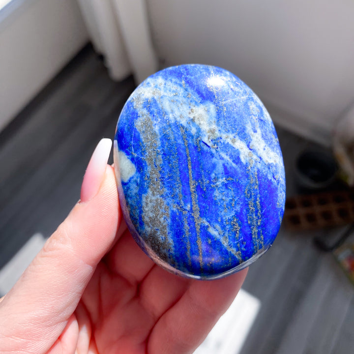 Hand holding a blue and white marbled stone