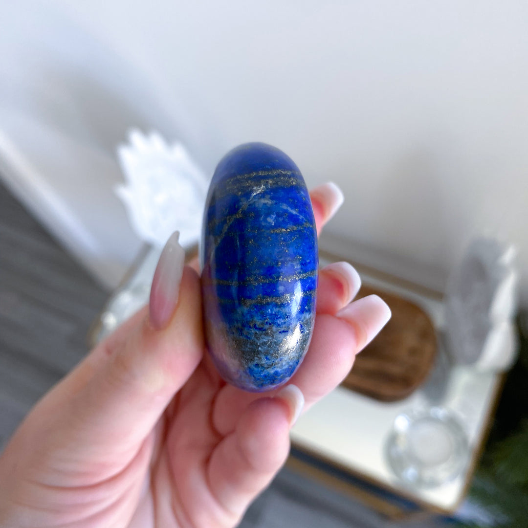 Hand holding a blue stone with a blurred background