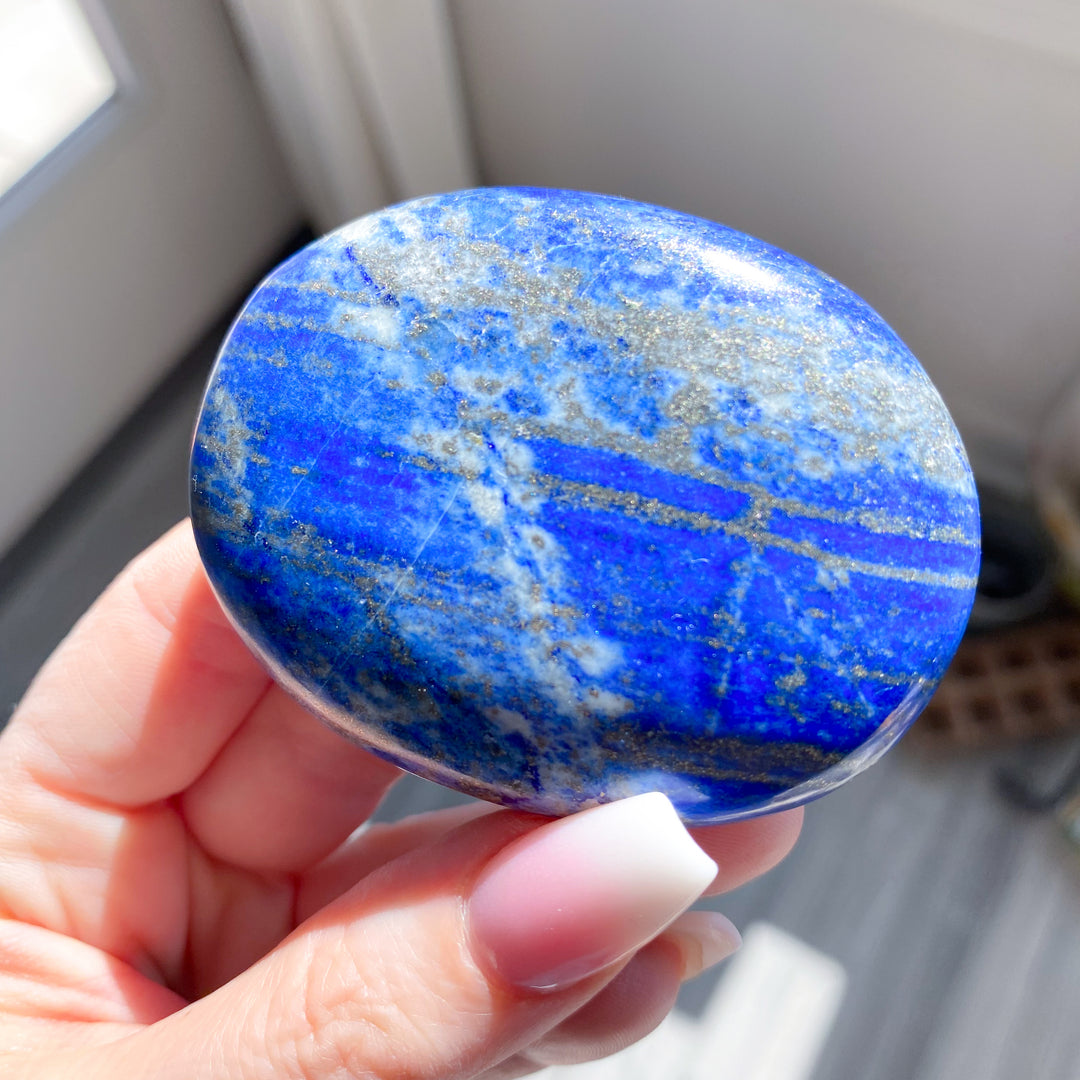 Hand holding a blue and white marbled stone