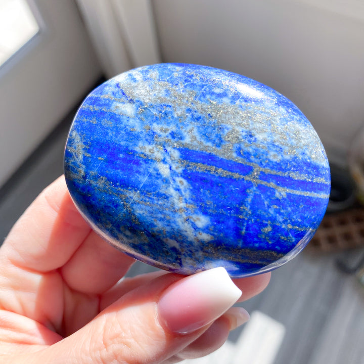 Hand holding a blue and white marbled stone