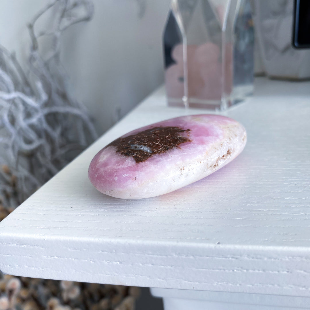 Pink stone with a dark center on a white surface