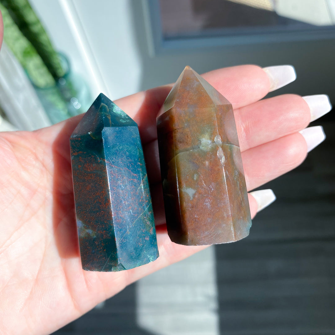 Two crystal stones held in a hand with a blurred background
