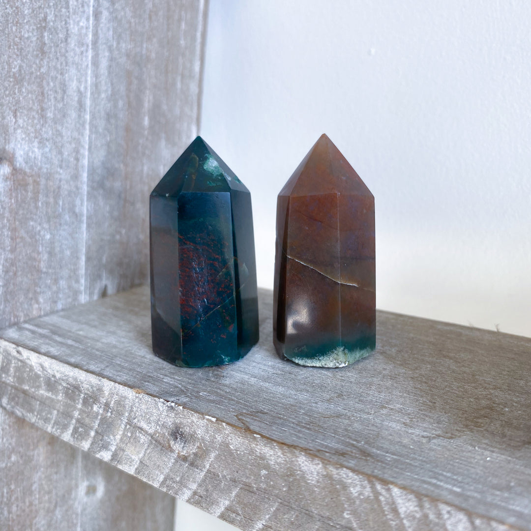 Two crystal towers on a wooden surface with a neutral background