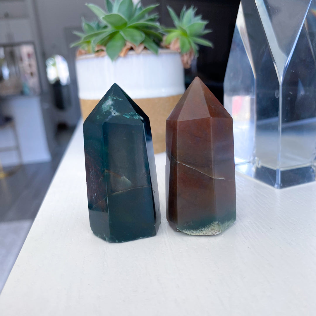 Two crystal towers on a white surface with a blurred indoor background