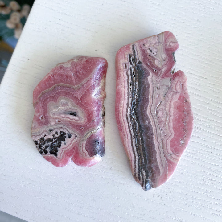 Two pink and gray marbled stones on a white surface