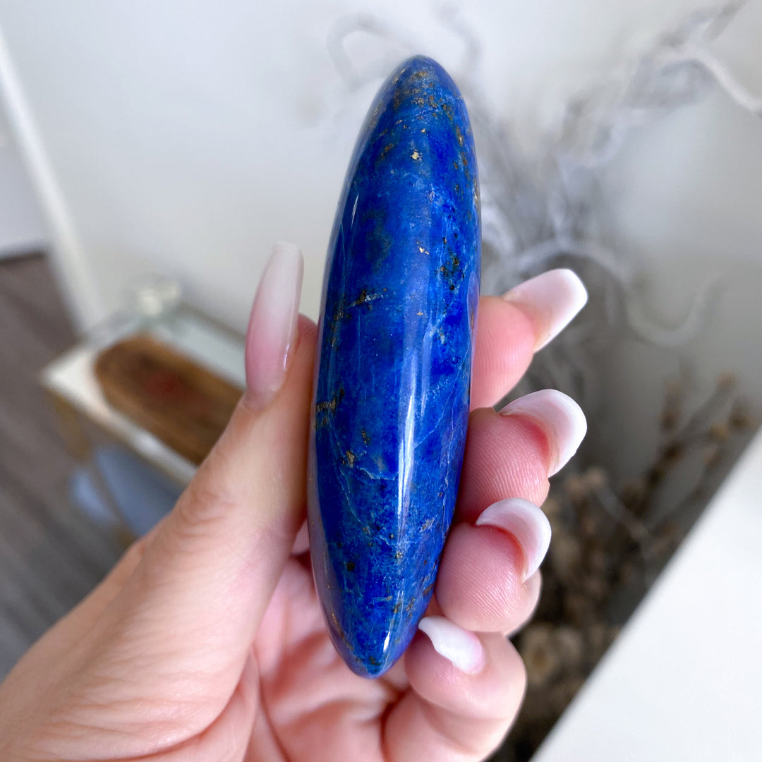 Hand holding a blue stone with a blurred background
