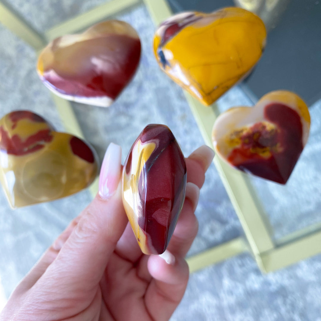 Heart-shaped marbled candies held by a hand with a blurred background