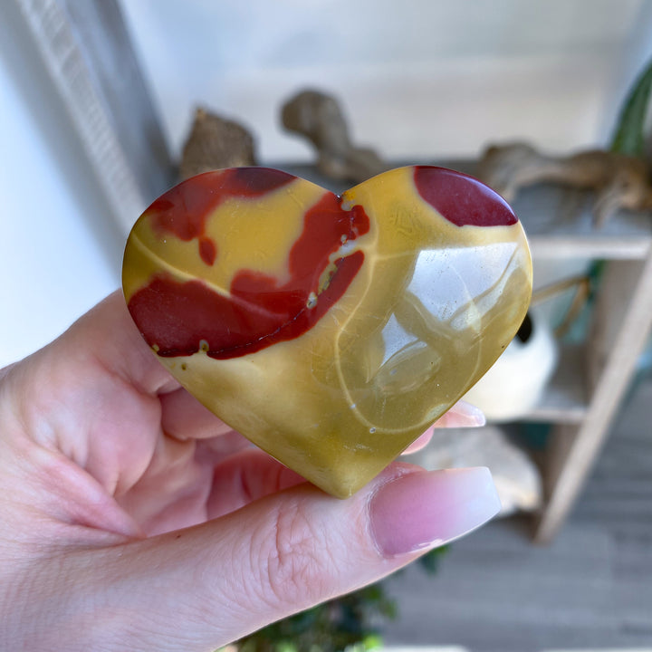 Heart-shaped marbled stone held in a hand with a blurred background